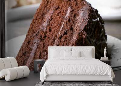 Delicious chocolate cake in white plate on wooden table background, closeup Wall mural