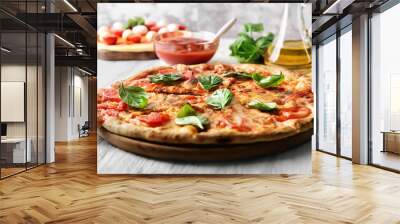 Delicious pizza with tomatoes and fresh basil on kitchen table Wall mural