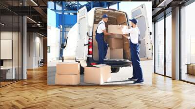 Delivery men unloading moving boxes from car Wall mural