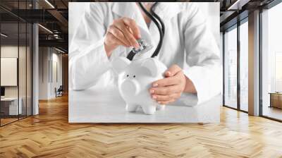 Doctor hands with piggy bank closeup Wall mural