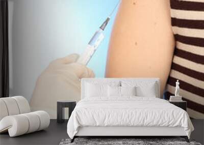 Doctor holding syringe with a vaccine in the patient shoulder, Wall mural