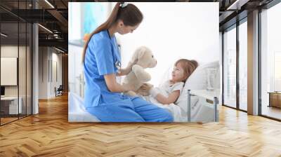 Doctor visiting little girl in hospital room Wall mural