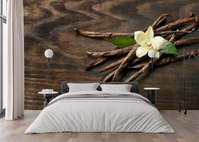 dried vanilla pods and flower on wooden background Wall mural