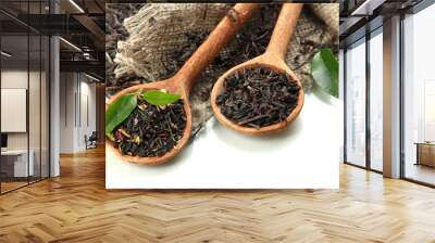 dry tea with green leaves in wooden spoons, isolated on white Wall mural