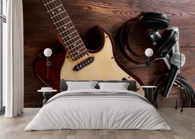 Electric guitar with microphones and headphones on wooden table close up Wall mural