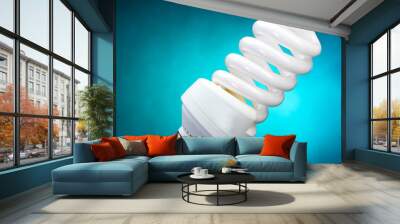 Energy saving lamp on blue background Wall mural