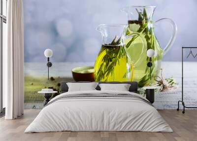 Essential Oil with rosemary in glass jug, on light background Wall mural