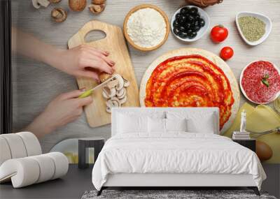 Female hands cooking pizza on wooden table, closeup Wall mural