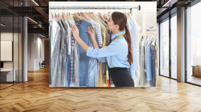 Female worker in dry-cleaning salon Wall mural