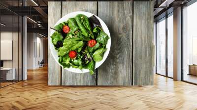 Fresh green salad in bowl on wooden table Wall mural