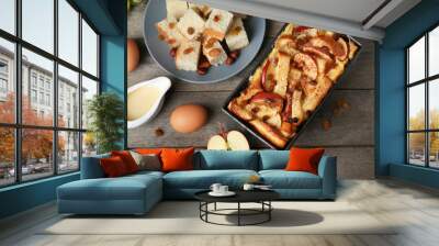 Freshly baked bread pudding in casserole dish and ingredients on wooden table Wall mural