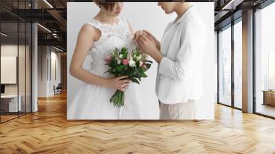 Gay wedding concept. Happy married lesbian couple on light background Wall mural