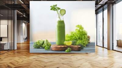 Glass bottle with fresh green juice and ingredients on table Wall mural