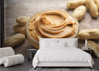 Glass bowl with peanut butter on wooden background Wall mural