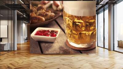 Glass of beer, chicken wings and grilled sausages on wooden table, close up Wall mural