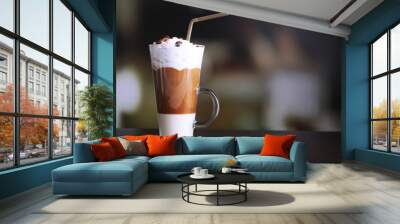 Glass of coffee on color wooden table, on dark background Wall mural