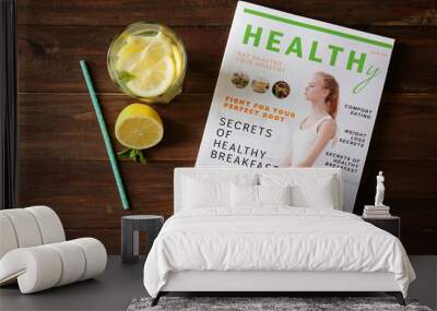 Glass of fresh lemonade and magazine on wooden background Wall mural