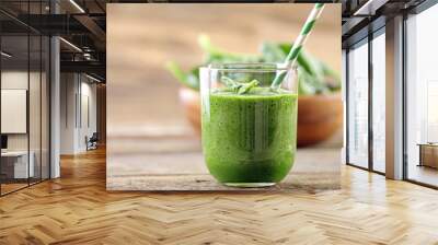 Glass of spinach juice on wooden background Wall mural