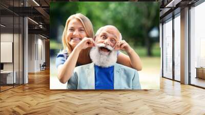 Grandfather and granddaughter sitting in a park Wall mural