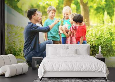 Group of children with teacher in park on sunny day Wall mural