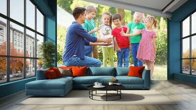 Group of children with teacher in park on sunny day Wall mural