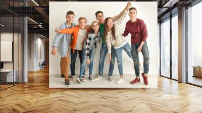 Group of cute teenagers standing near white wall Wall mural