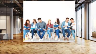 Group of people reading books while sitting near light wall Wall mural