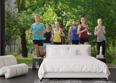 Group of young people running in park Wall mural