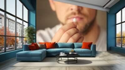 Hand of young man with pill, closeup Wall mural