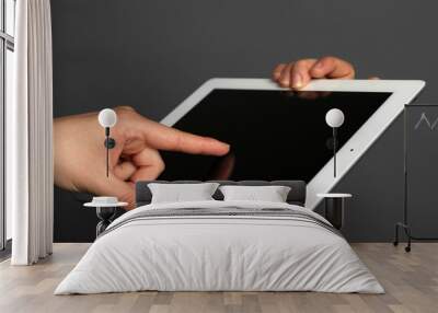 Hands holding tablet on gray background Wall mural