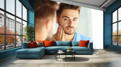 Handsome unshaven man looking in mirror Wall mural