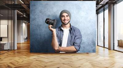 Handsome young photographer near grey textured wall Wall mural