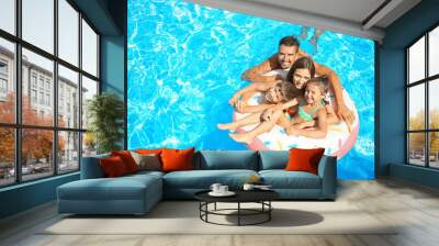 happy family with inflatable ring relaxing in swimming pool Wall mural