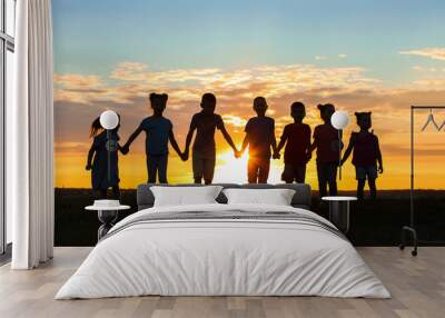 Happy kids silhouettes on sunset background Wall mural