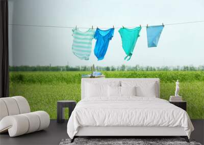 Laundry line with clothes in field Wall mural