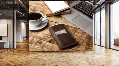 Leather case with mobile phone, laptop, notepads and cup of coffee on wooden table Wall mural