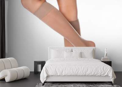 Legs of beautiful young woman in knee socks on white background Wall mural