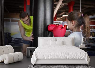 Little girl training with coach and punchbag in boxing gym Wall mural