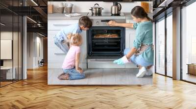 little kids watching their mother bake cookies in oven indoors Wall mural