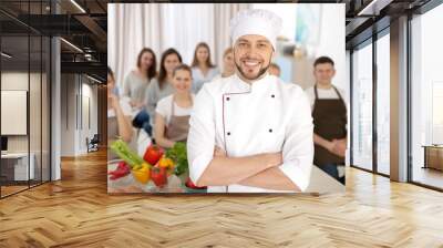 Male chef and group of people at cooking classes Wall mural