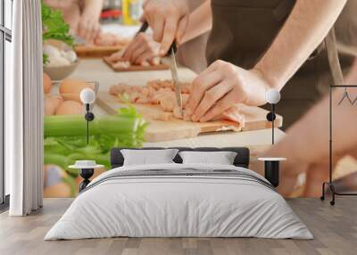 Man cutting chicken fillet at cooking classes Wall mural