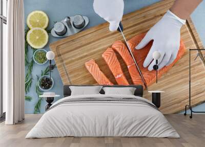 Man cutting fresh salmon fillet in kitchen Wall mural