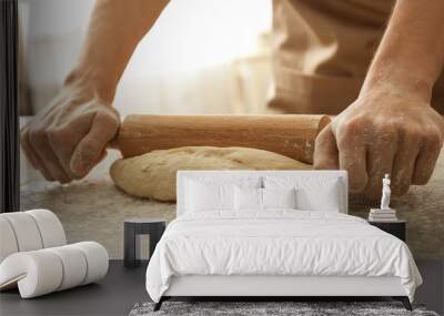 Man rolling out dough on kitchen table, close up Wall mural