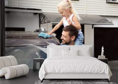 Man with little daughter washing car outdoors Wall mural