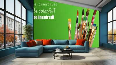 Many brush in paint on green background Wall mural