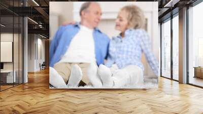 Mature couple sitting together on a floor at home Wall mural