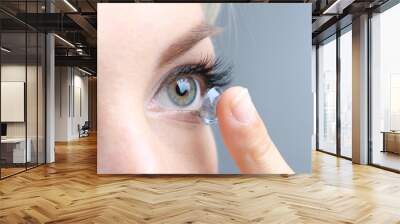 medicine and vision concept - young woman with contact lens, Wall mural