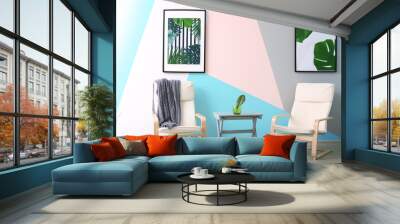 Modern room design with framed pictures of tropical leaves and two chairs Wall mural