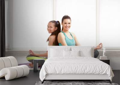 Mother and daughter doing exercise indoors Wall mural