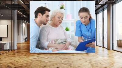 nurse talking with grandmother and her grandson indoors Wall mural